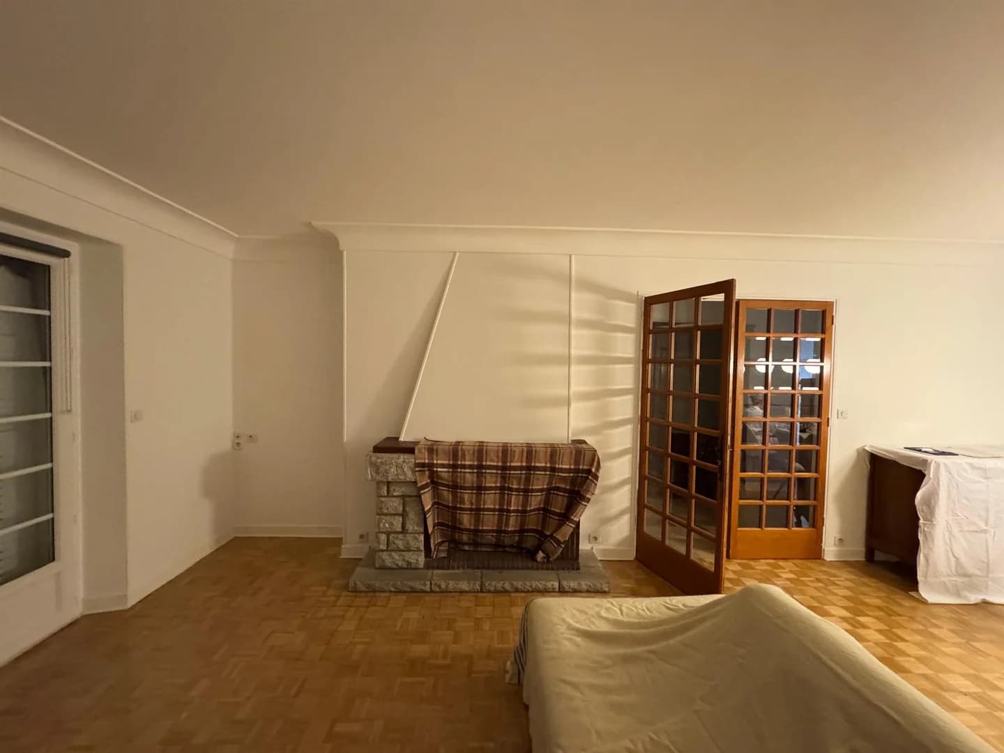 Salon rénové avec cheminée en pierre et parquet conservé dans le Nord
