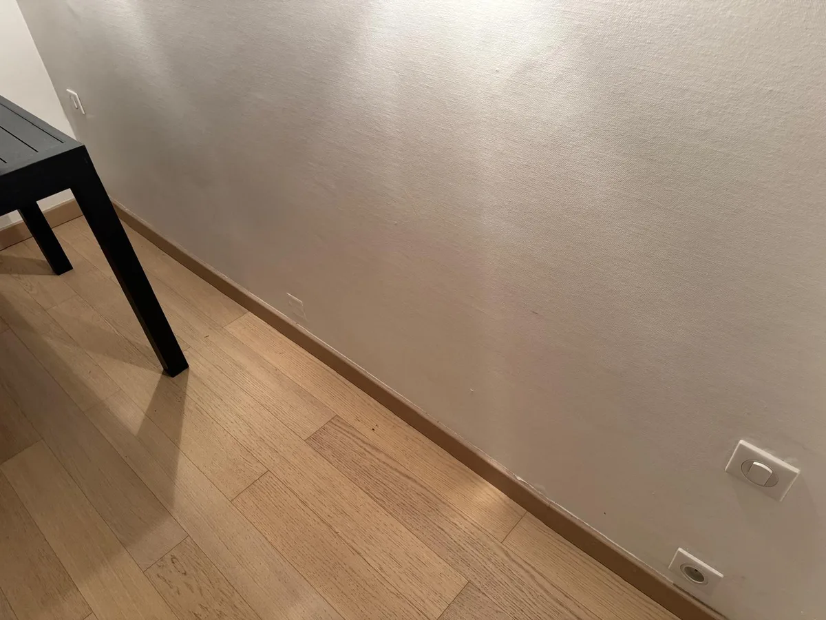 Détail du parquet conservé et des finitions en pied de mur