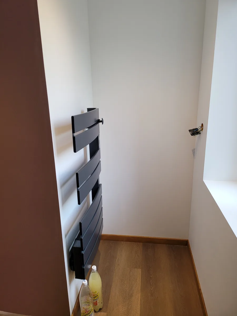 Sèche-serviettes noir installé dans la salle de bain