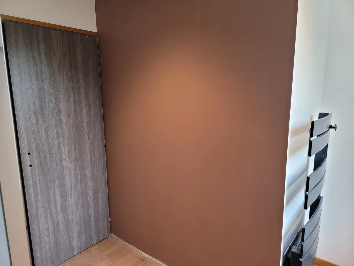 Mur aux tons chauds et porte intérieure de la salle de bain