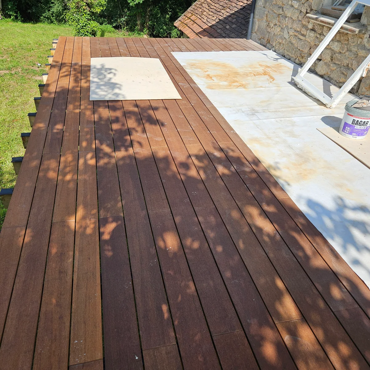 Pose de lames sur une terrasse bois attenante à une maison en pierre